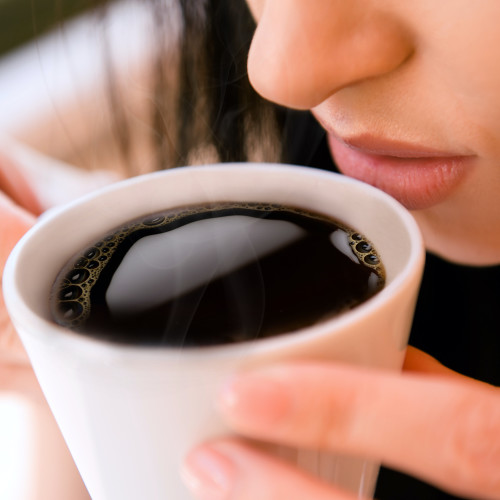 woman sipping a cup of kcup black coffee